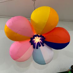 a large multicolored flower shaped balloon hanging from the ceiling