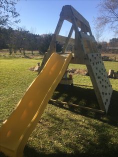 a yellow slide sitting in the middle of a field