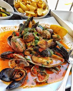 a white plate topped with clams and sauce