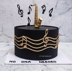 a black and gold cake with musical notes on the top that says no one needed