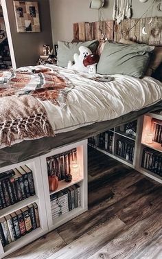 a bed with bookshelves underneath it and stuffed animals on the headboard,