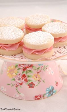 some cookies are sitting on a plate with pink frosting