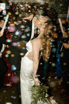 a bride and groom are kissing in front of bubbles on the dance floor at their wedding