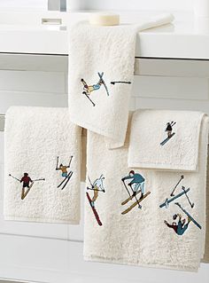 towels with skiers on them hanging from a towel rack