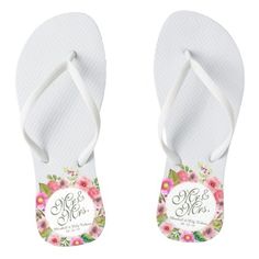 a pair of white flip flops with pink flowers on them