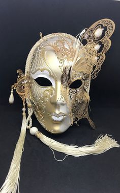 Venetian Mask for decoration - Traditional and original papier-mache Venetian mask, handmade and decorated with metal insert, gold-leaf and glitters,enriched with Swarovski crystals. Dimension: All our masks are handmade papier-machè masks made in Venice. Our decorators use techniques typical of the Venetian tradition such as stucco, acrylics, gold and silver-leaf, macramè, passementerie, glitters and crequelè to offer you a wide range of original handmade masks and decorations This shape is ava Traditional Gold Masks And Prosthetics For Costume, Artistic Gold Masks And Prosthetics For Festivals, Traditional Gold Mask For Mardi Gras, Traditional Gold Costume Masks And Prosthetics, Gold Carnival Masks And Prosthetics As Gifts, Gold Masks And Prosthetics For Carnival Gift, Traditional Gold Masks For Carnival, Artistic Gold Masquerade Mask For Costume, Traditional Gold Masks And Prosthetics For Carnival