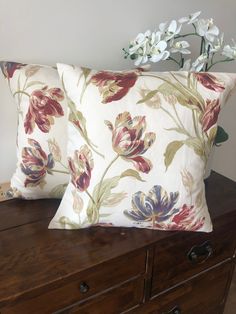 two pillows on top of a wooden dresser