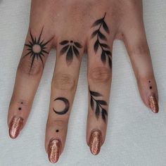 a woman's hand with tattoos on it and an arrow, sun and moon