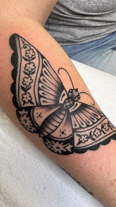 a black and white butterfly tattoo on the arm