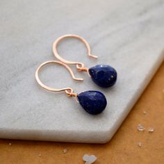 Our Midnight Earrings are cobalt blue with dainty gold inclusions - like the dark sacred night sky with stars twinkling. These Lapis Lazuli earrings feature faceted gemstones in an inky dark blue hue with golden striations. We hand wire-wrap the gemstones in our signature tightrope style, anchored beneath our classic lure earwires. Available in affordable Gold Fill, Sterling Silver, and Rose Gold Fill; or heirloom-quality solid 14K Gold (Yellow, Rose, or White Gold). Our high quality sustainable Lapis Lazuli Teardrop Earrings For Gifts, Teardrop Lapis Lazuli Earrings For Gift, Lapis Lazuli Teardrop Earrings As Gift, Lapis Lazuli Teardrop Jewelry With Matching Earrings, Teardrop Lapis Lazuli Jewelry With Matching Earrings, Handmade Lapis Lazuli Jewelry For Everyday, Minimalist Jewelry Earrings, Drop Earrings Simple, Gemstone Drop Earrings