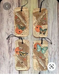 three tags with butterflies on them are hanging from the wood planked wall, one is made out of old book pages and the other has been altered