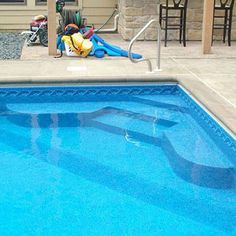 a blue swimming pool with an inflatable slider next to it