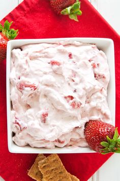 strawberry fluff dip in a white bowl with crackers and strawberries on the side