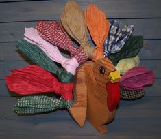 a wooden turkey head with many different colored ribbons on it's back and sides