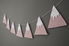 some pink and white paper mountains hanging from a string