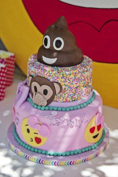 a three tiered cake decorated with sprinkles and monkey faces