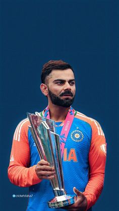 a man with a beard holding two trophies