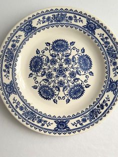 a blue and white plate with floral designs on the rim is sitting on a table