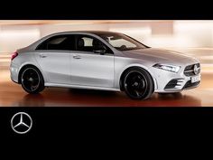 a white mercedes cla parked in front of a building with black rims and wheels