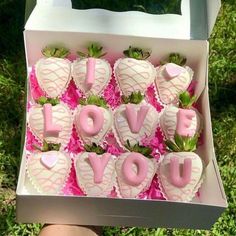 someone is holding up a box of chocolates with strawberries in the shape of hearts