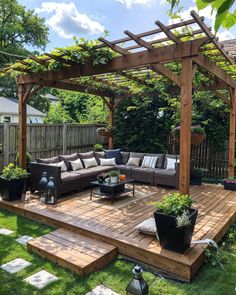 an outdoor living area with couches, tables and potted plants on the deck