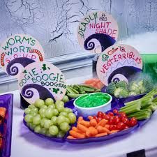 a table topped with purple plates filled with veggies