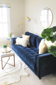 a living room with a blue couch and white rug