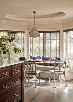 a living room filled with furniture next to a window covered in shutters and flowers