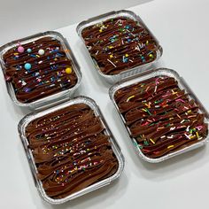 four square trays filled with chocolate frosting and sprinkles