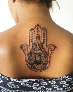 a woman with a hamsa tattoo on her back