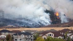 a fire is burning in the distance behind houses