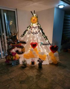 there is a christmas tree made out of balloons and other items on the floor in front of it