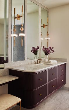 an elegant bathroom with marble counter tops and large mirrors on the wall over the sink