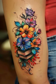 colorful flowers and books tattoo on the thigh