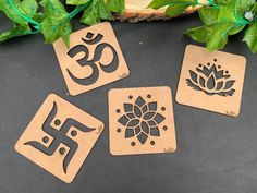 four wooden coasters with the number 35 and lotus symbol on them, sitting next to some green leaves