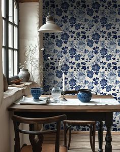 a dining room table with blue and white wallpaper