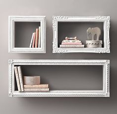 two white bookshelves with decorative items on them in front of a gray wall