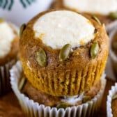 several cupcakes with white frosting and pumpkin seeds