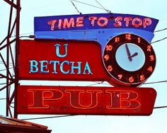 a neon sign that says u betcha pub with a clock on the front and back