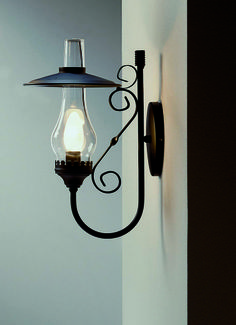 a light that is on the wall next to a white wall with a black lamp