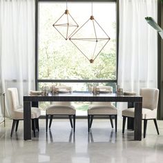 a dining room table with four chairs and a chandelier hanging from the ceiling