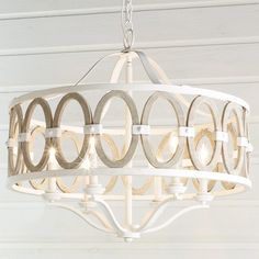 a white chandelier with circles hanging from it's center and two lights on each side