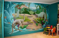 a child's bedroom decorated in blue and green with dinosaurs painted on the wall