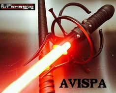 a red light saber is on top of a black metal surface with the words avispa written below it