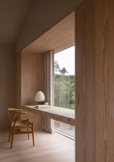 a chair sitting in front of a window next to a wooden table