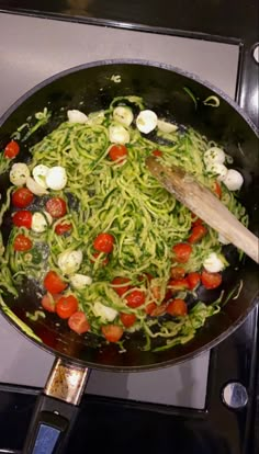 a pan filled with pasta and vegetables cooking on the stove