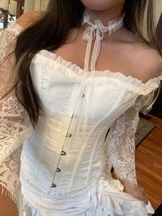 the woman is wearing a white corset