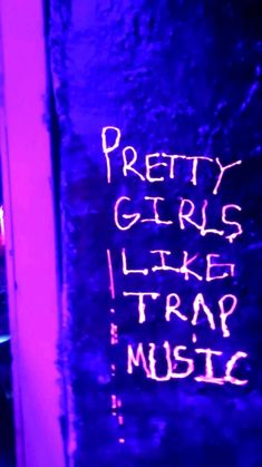 graffiti written on the side of a wall next to a street sign that says pretty girls like trap music