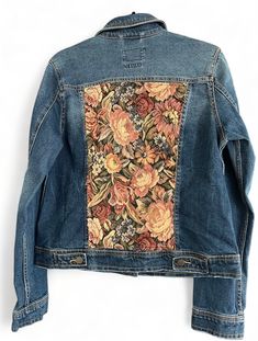 a jean jacket with flowers on it hanging from the back, and an open pocket