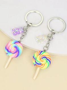 two lollipop keychains are shown on a white surface, one is multicolored